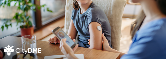 Mom holding smartphone with app for her daughter's CGM device