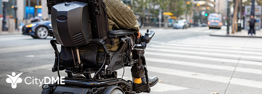 Man in power wheelchair riding across a crosswalk in New York