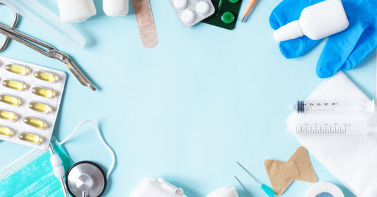 A blue table with different medical supplies, such as gauze, a stethoscope, bandages, and more, all placed in a circular formation.